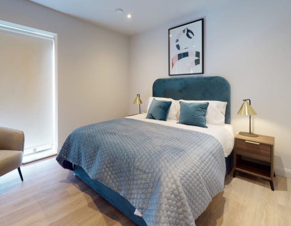 a bedroom with a large bed and a blue and white comforter