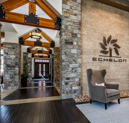the lobby of a hotel with two chairs and a reception desk