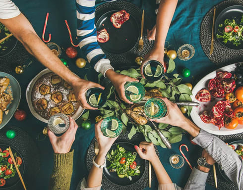 a group of people sitting around a dinner table eating food
