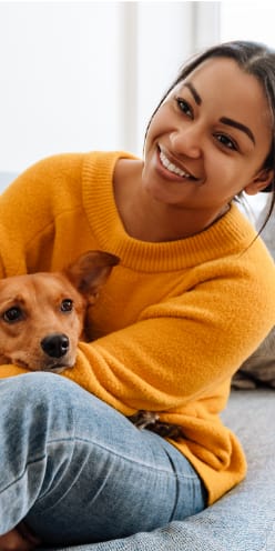 a woman sitting on a couch with her dog on her lap