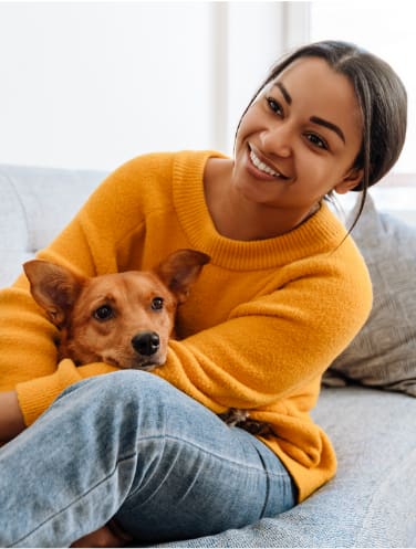 a woman sitting on a couch with her dog on her lap