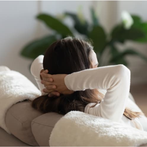 a woman laying on a couch with her head in her hands