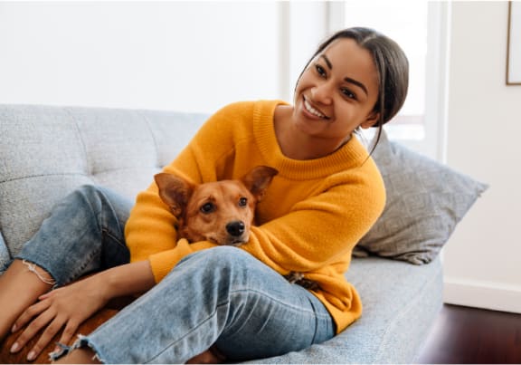 a woman sitting on a couch with her dog on her lap