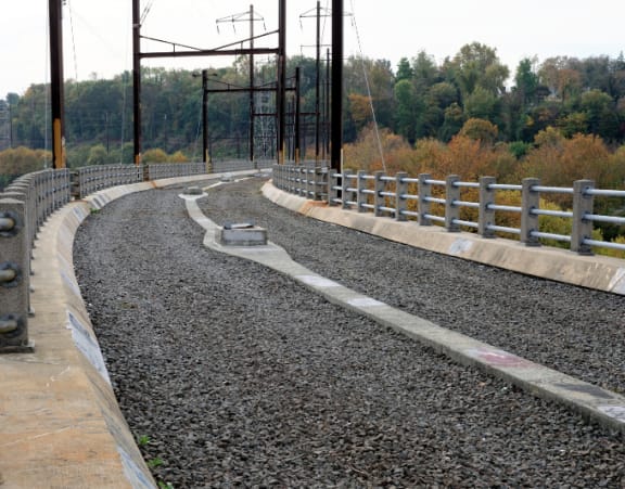 a curve in a gravel road on a bridge