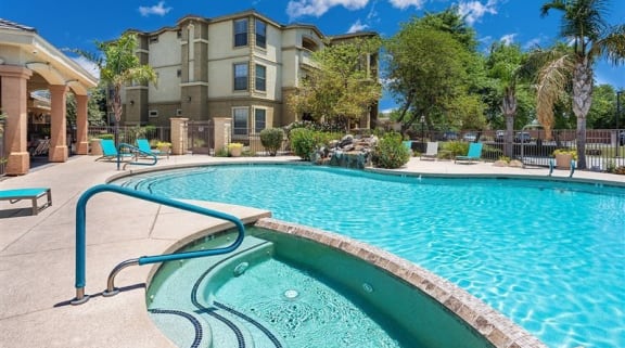 A swimming pool in front of a building with a blue sky in the background. at Superstition Canyon, Mesa, Arizona