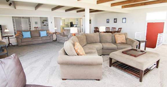 A living room with a grey couch and a brown leather chair.