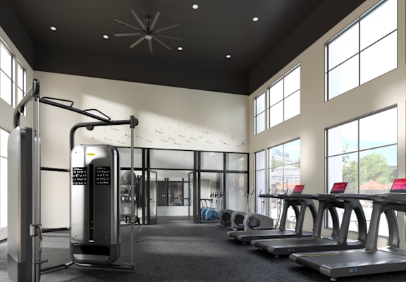 a gym with cardio equipment and windows in a building