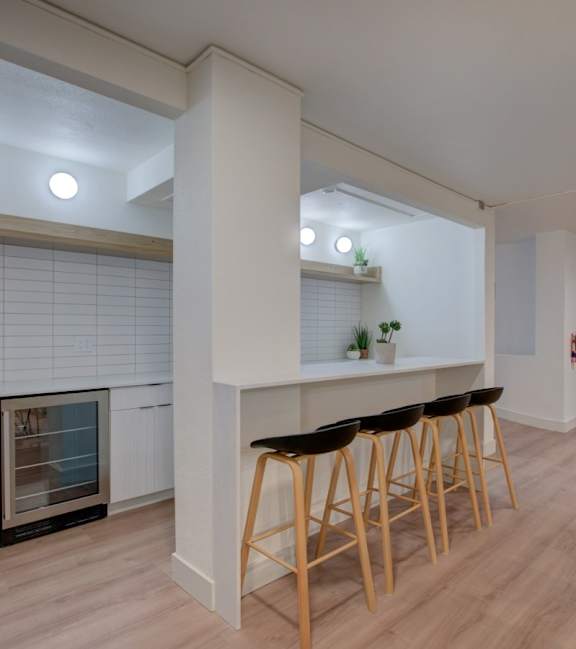A kitchen with a bar area and a microwave.