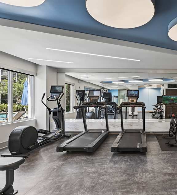 A gym with treadmills, exercise bikes, and other equipment.