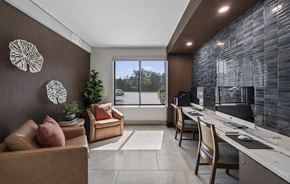 A modern living room with a brown couch and a stone wall.