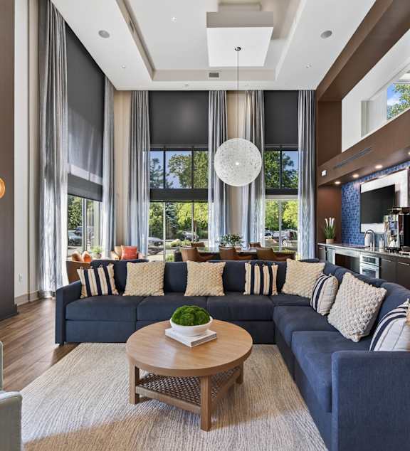 A modern living room with a dark blue sofa and a wooden coffee table.