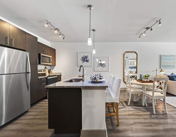 A modern kitchen with a dining area and a couch.