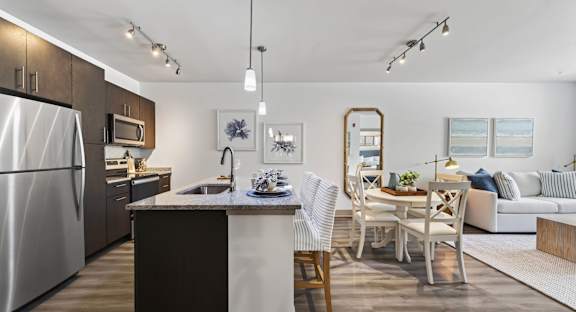 A modern kitchen with a dining area and a couch.
