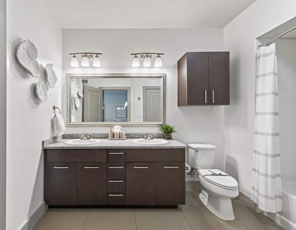 A bathroom with a white toilet and a brown cabinet.