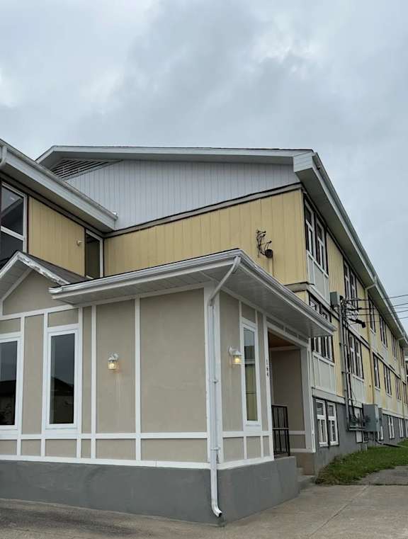 A two-story building with a yellow and white exterior.