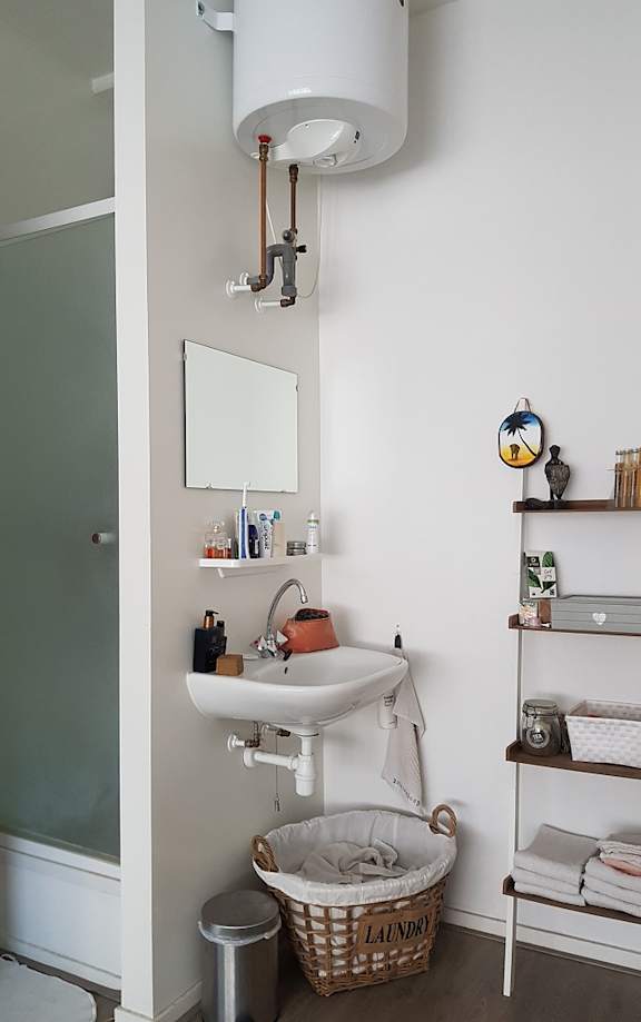 A bathroom with a white sink and a mirror above it.