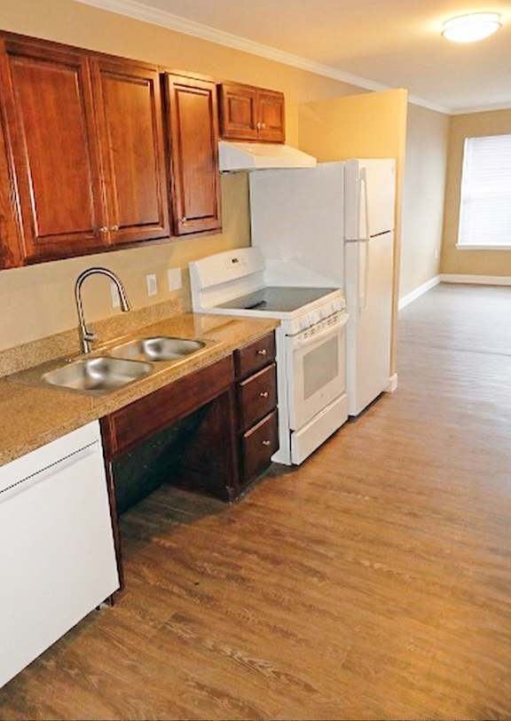 A kitchen with wooden cabinets and white appliances.