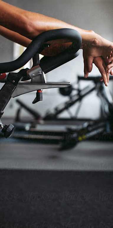 a person holding an exercise bike in a gym