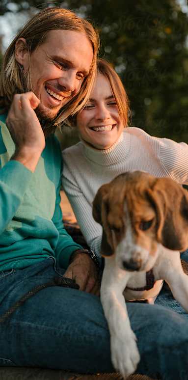 a man and woman sitting with a dog