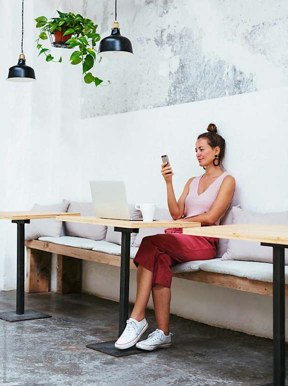a woman sitting at a table looking at her cell phone