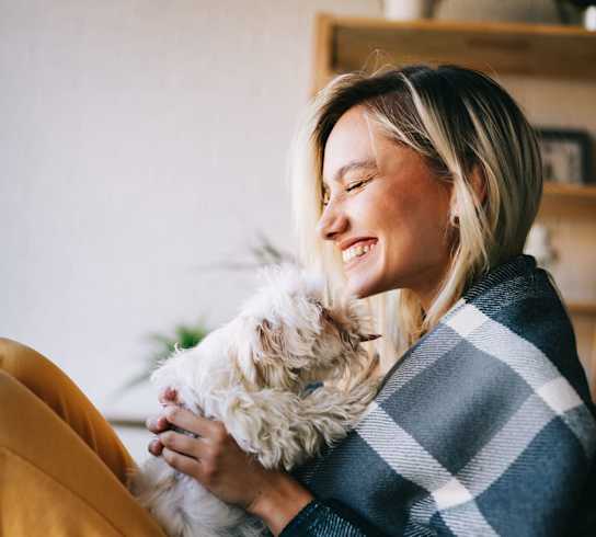 a woman sitting in a chair holding a dog