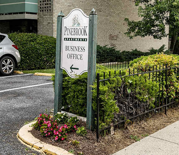 a sign for a business office in front of a fence