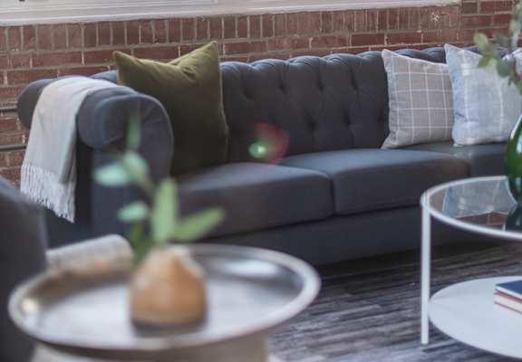 a living room with a couch and a brick wall