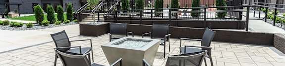 A patio with a table and chairs2 and a fountain.