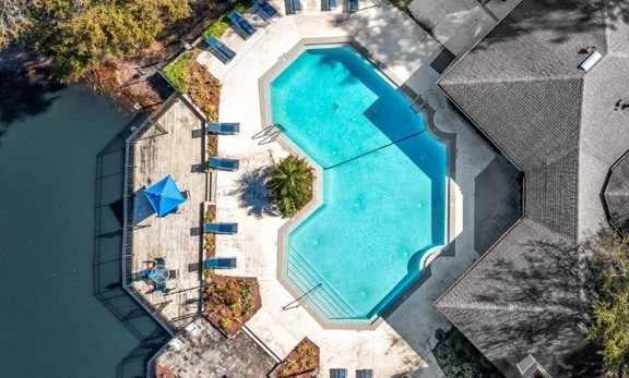an aerial view of a swimming pool in a backyard with a house and a pool