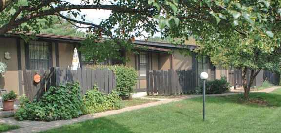 a small house with a yard and a fence