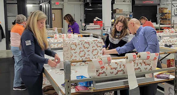 A man and woman are working on a project together in a workshop.