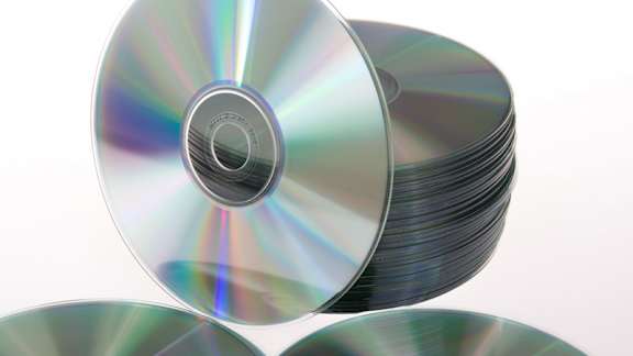 A stack of CDs with one lying flat on top.