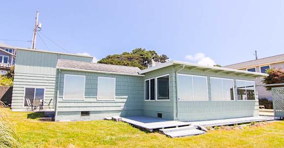 A house with a green exterior and a white roof.