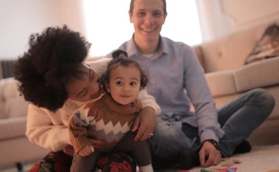 happy parents with toddler in apartment home