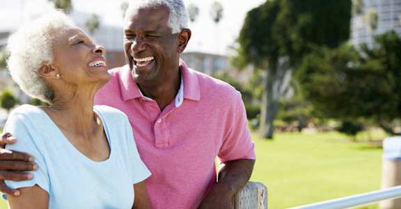 Senior couple laughing outside