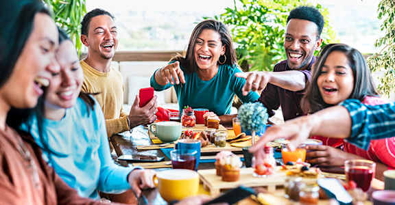 A group of people are gathered around a table enjoying a meal and drinks.