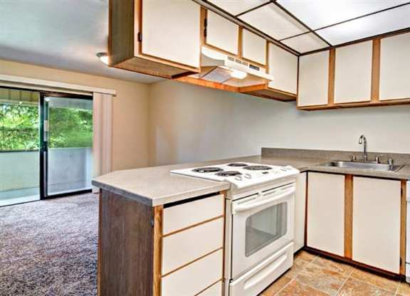 Milton Apartments - Autumn Village Apartments - Living Room, Kitchen, and Deck