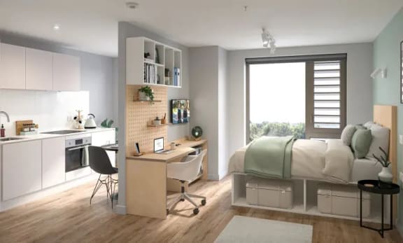 a bedroom with a desk and kitchenette