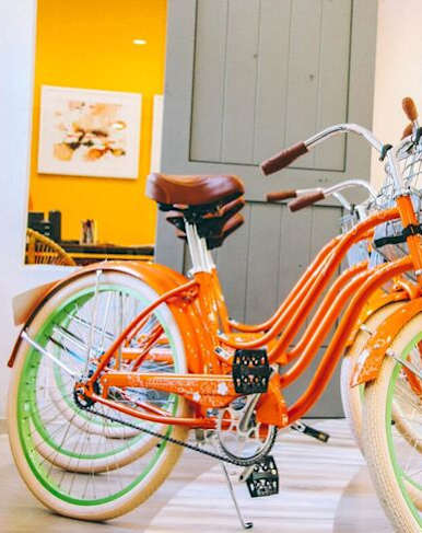 A bicycle with a basket is parked in a room.