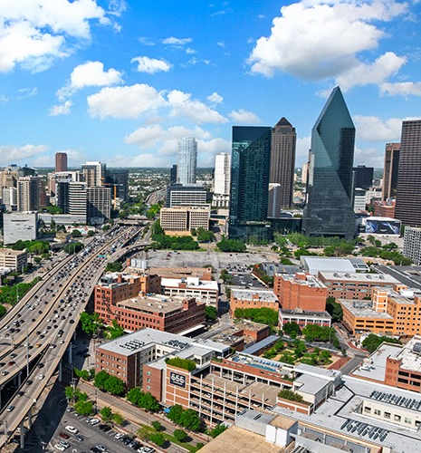 A cityscape with a clear blue sky and a highway running through it.