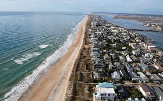 A beachfront city with buildings and a sandy beach.