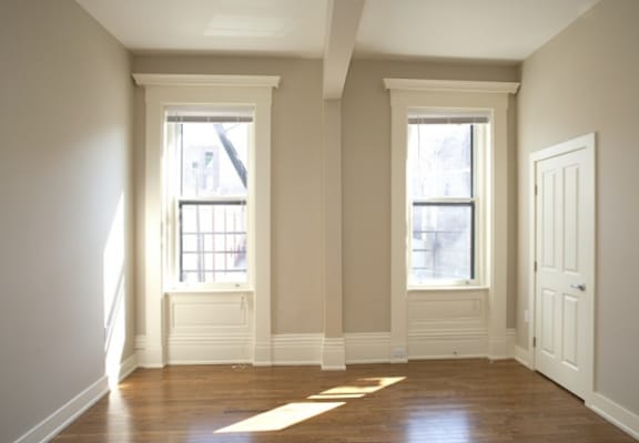 an empty room with two windows and a door