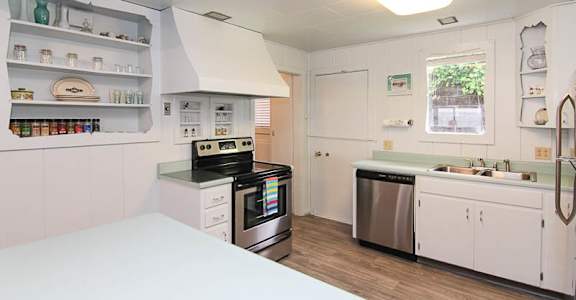 A kitchen with white cabinets and a stainless steel dishwasher.