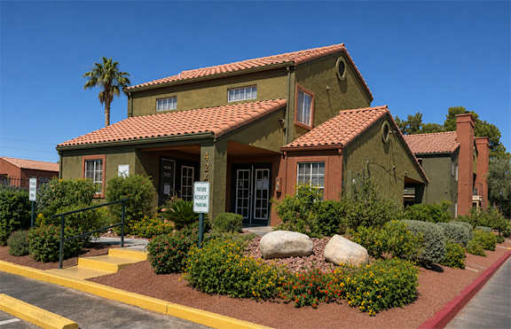 A house with a red tile roof and a sign in front of it.