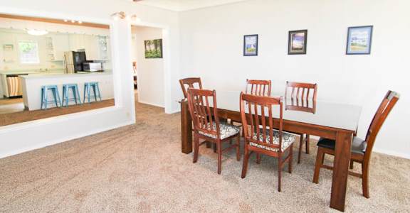 A dining room with a table and chairs.