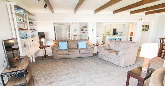 A living room with a grey couch and a brown armchair.