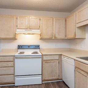 A kitchen with wooden cabinets and white appliances.