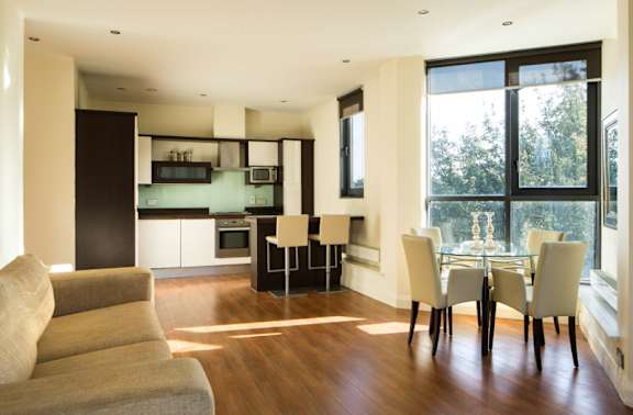 a living room and dining room with a table and chairs