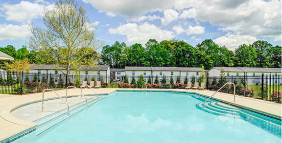 a swimming pool with a fence and trees in the background at Ashbrook Village, North Carolina, 28054