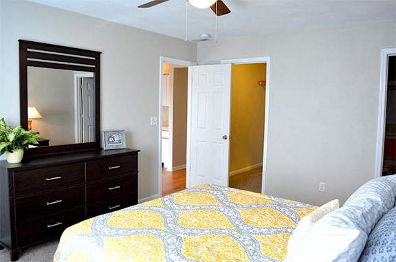 Bedroom with queen size bed, dresser, mirror, and walk-in closet